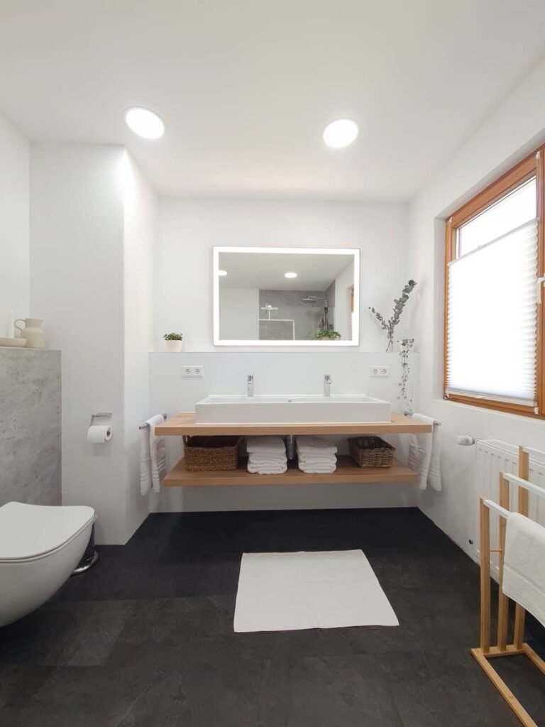 Bad 1 mit Waschtisch aus Holz, beleuchtetem Spiegel und WC