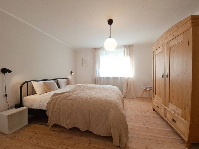 Schlafzimmer mit großem Doppelbett und Kleiderschrank aus Holz