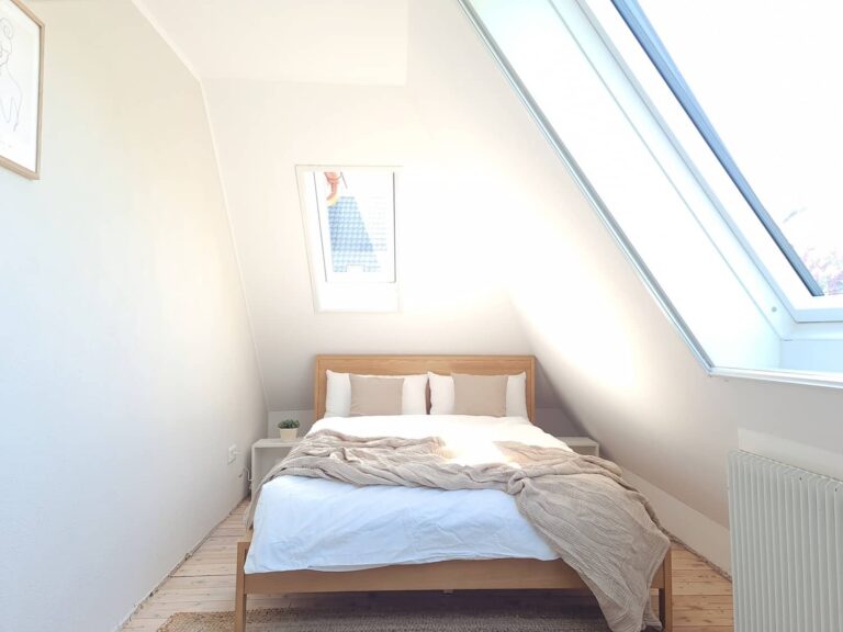 Schlafzimmer unter der Dachschräge mit großem Dachfenster