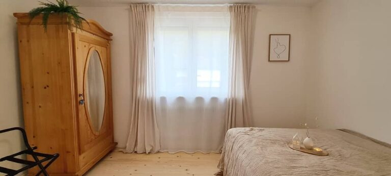 Schlafzimmer mit Spiegelschrank aus Holz und Kofferablage