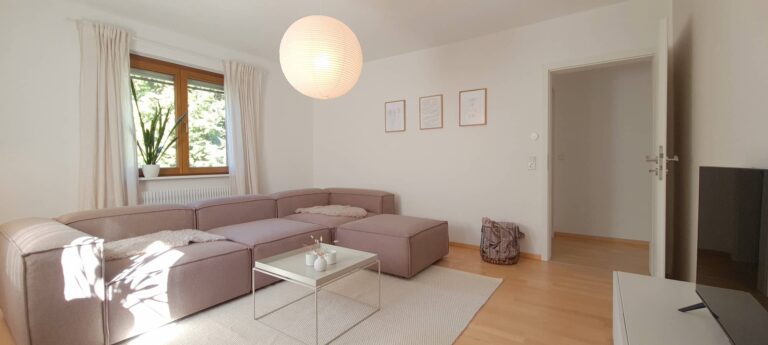 Wohnzimmer mit Ecksofa und Flachbildschirm, Blick zur Tür